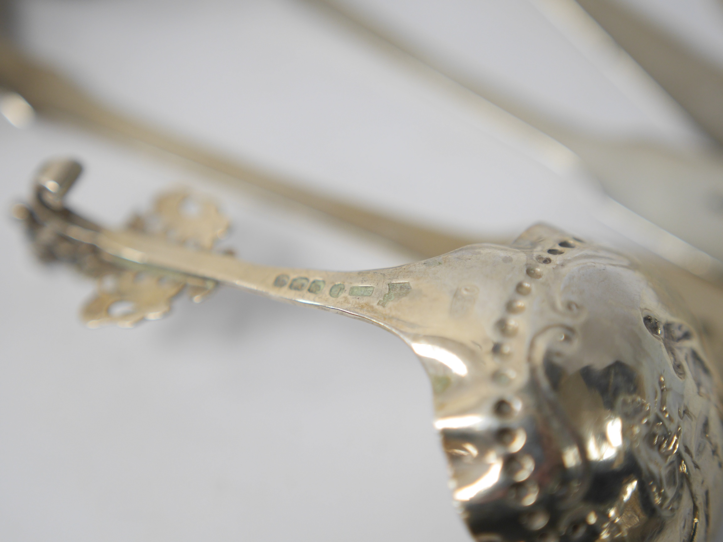 A late 19th century continental silver caddy spoon, with figural terminal, import marks for Sheffield, 1894, together with four assorted 19th century spoons including three table spoons and a sauce ladle, various dates a